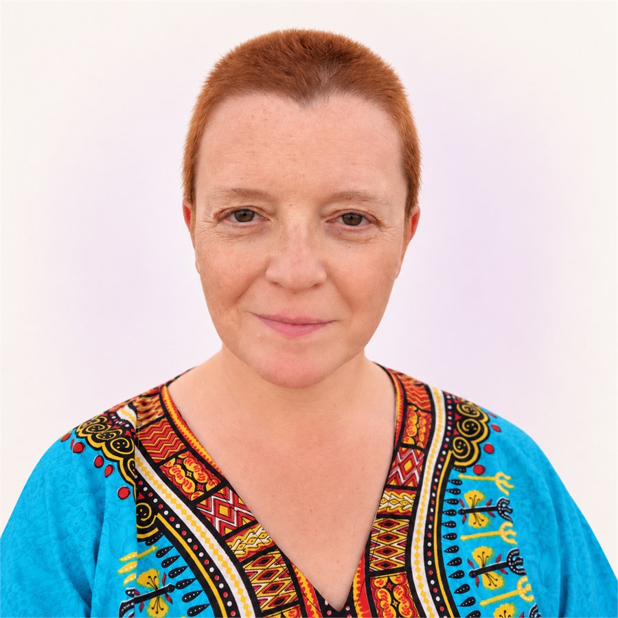 Frau mit kurzen kupfergoldenen Haaren, und blaue Bluse, lächelnd