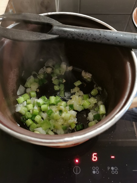 Jungzwiebel mit Olivenöl anschwitzen im Topf