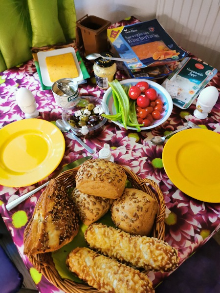 Sonntagsfrühstück, gedeckter Tisch mit Brötchen, Eier, Gemüse, Lachs