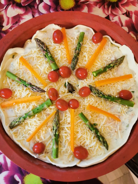 Spargel-Quiche-roh dekoriert mit grünem Spargel, Tomaten und Karotten