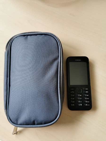 Kleines Handy mit riesigen Tasche