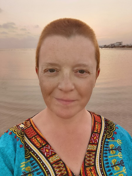 Frau mit Kupferblonden kurzen Haaren, im Hintergrund das Meer